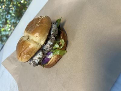 Smashed ground lamb patty, with blue cheese, lettuce, tomato, red onions on a brioche bun