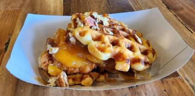 Where sweet and spicy meet at Gaston Street Eats! House made mini fluffy waffles, fried chicken tenders drizzled with 